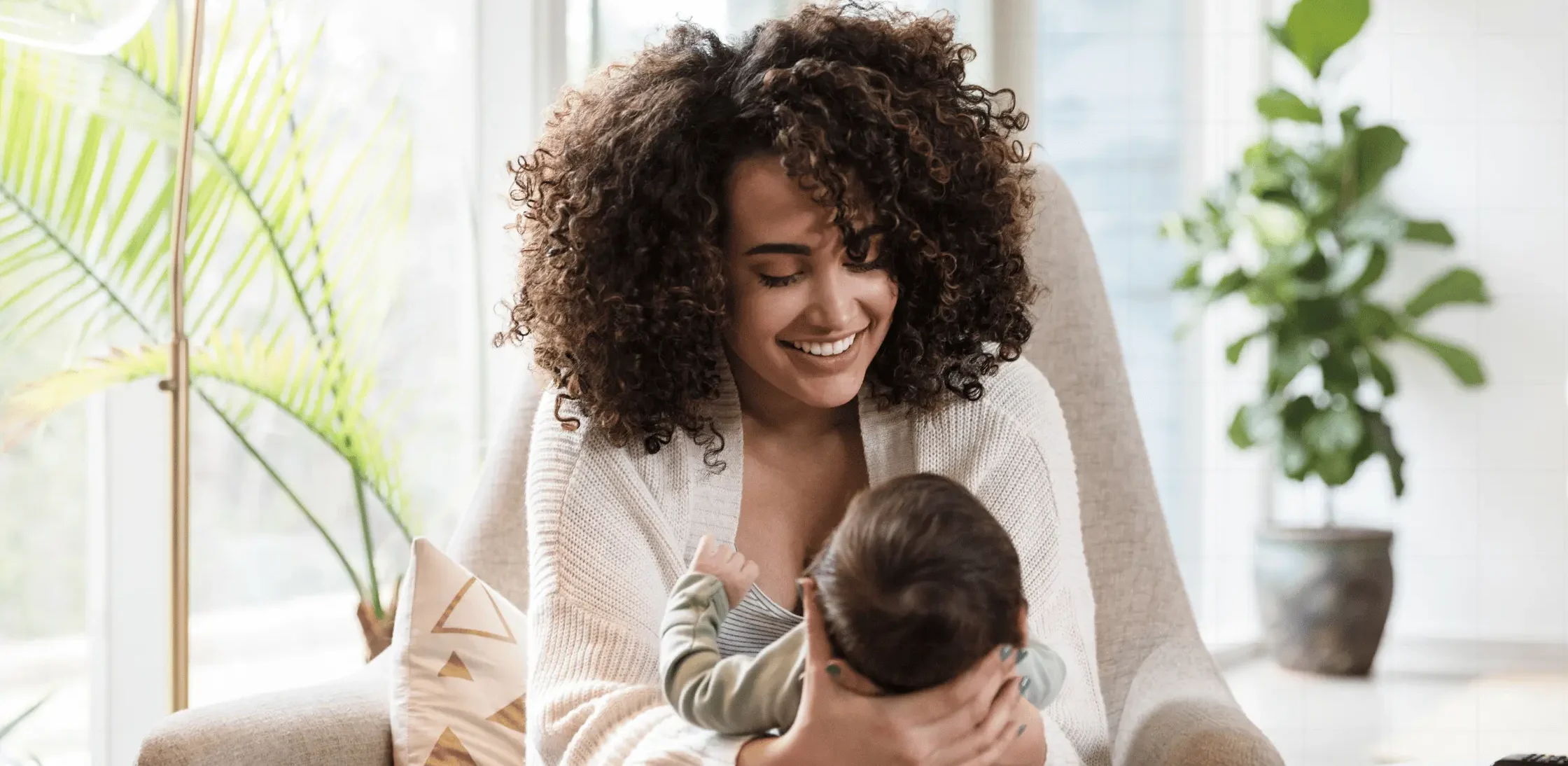 Newborn baby breastfeeding with mother receiving hands-on lactation guidance